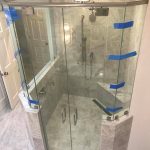 High angle view of a new glass shower with blue tape